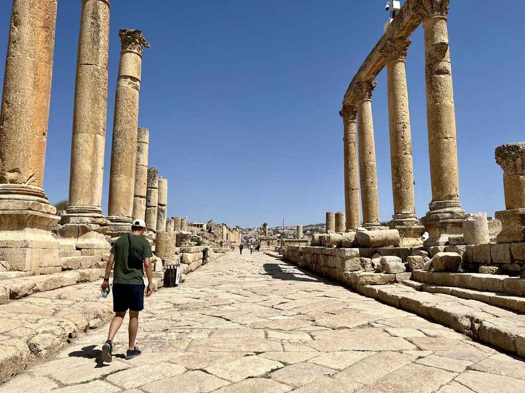 Rudy walking among the ruins of Jerash, but as it's touristic you might find scammers. Read along for my Jordan travel tips and the most common scams.